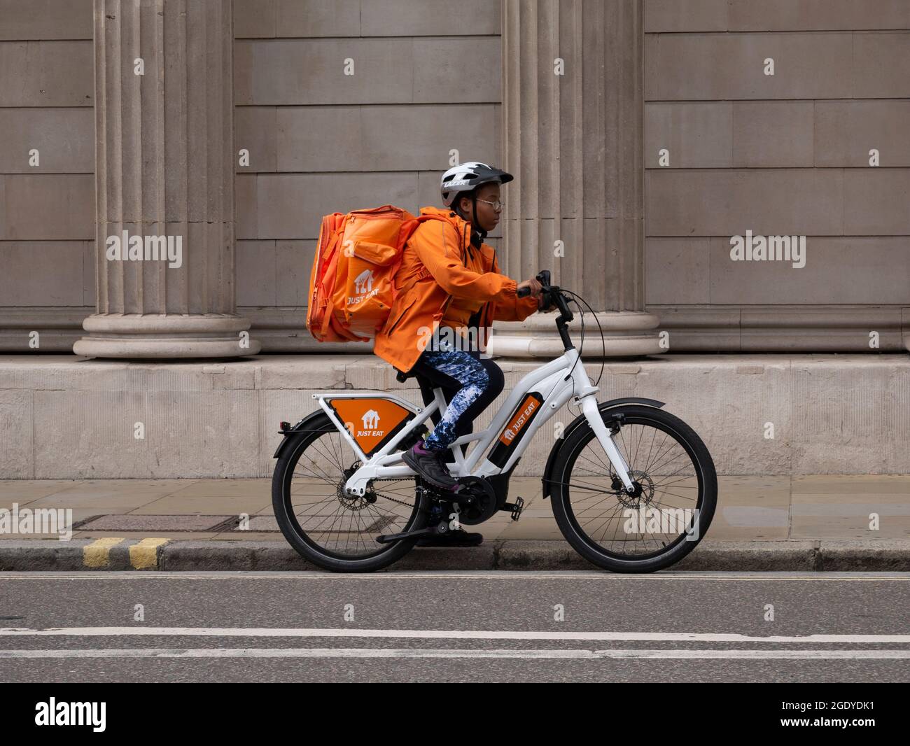Just Eat cycle delivery courier on electric bike outside the Bank