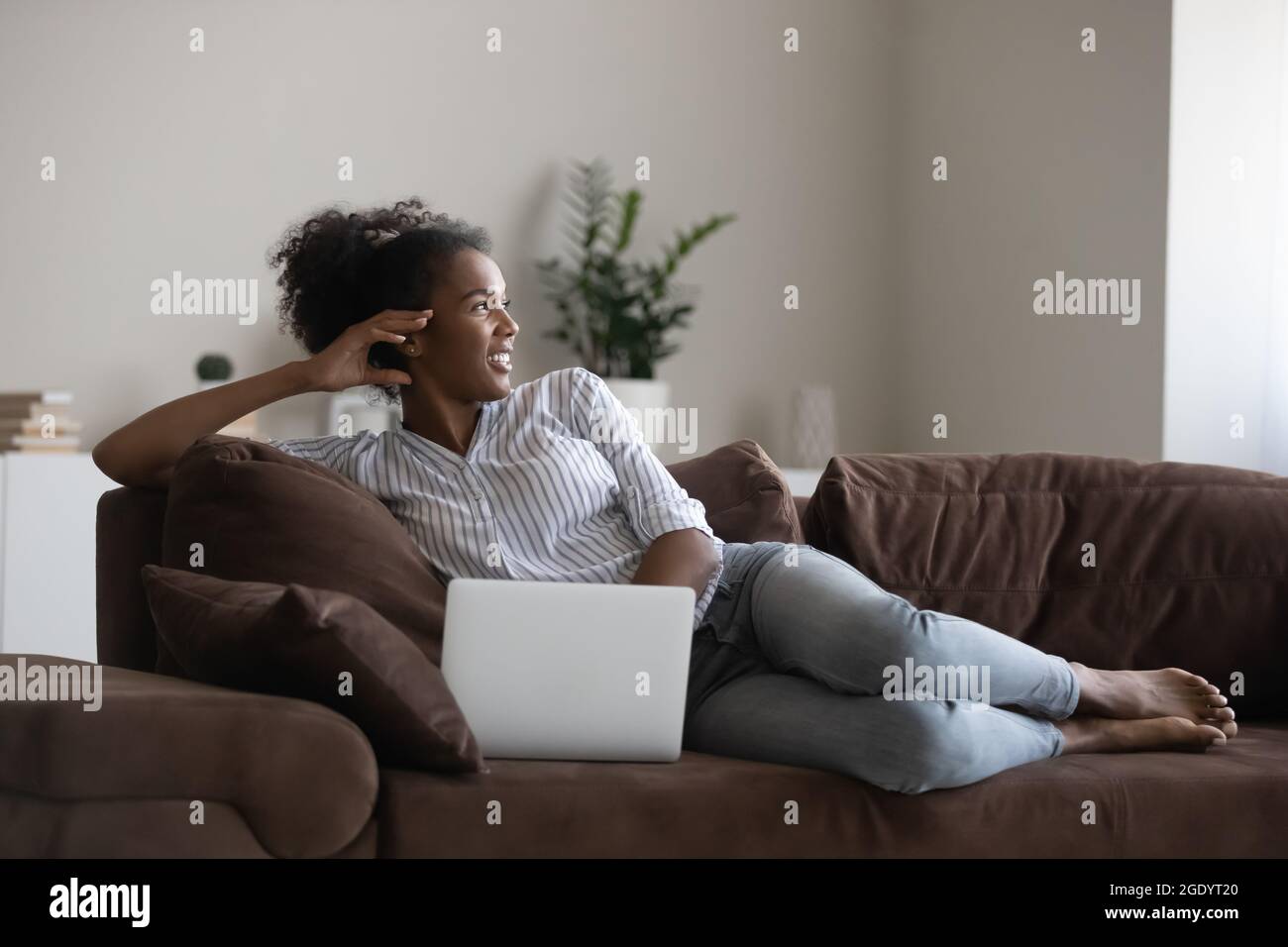 Happy African American woman relax on sofa with laptop Stock Photo - Alamy