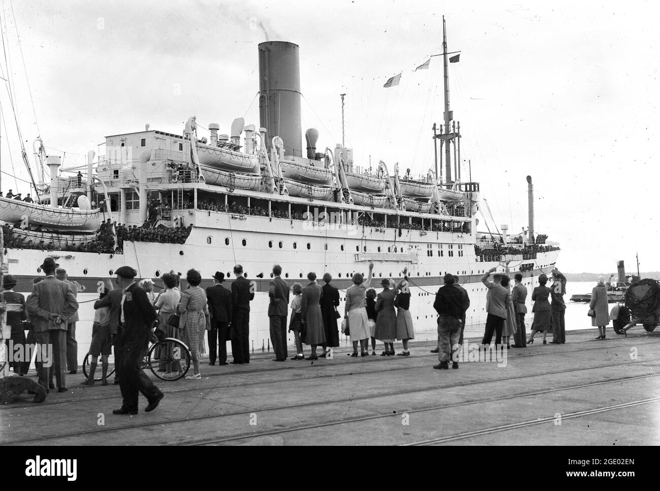 Families waving to soldiers and their family at Southampton docks as troop ship departs early 1950s HMT Empire Halladale or Poss Empire Trooper Stock Photo