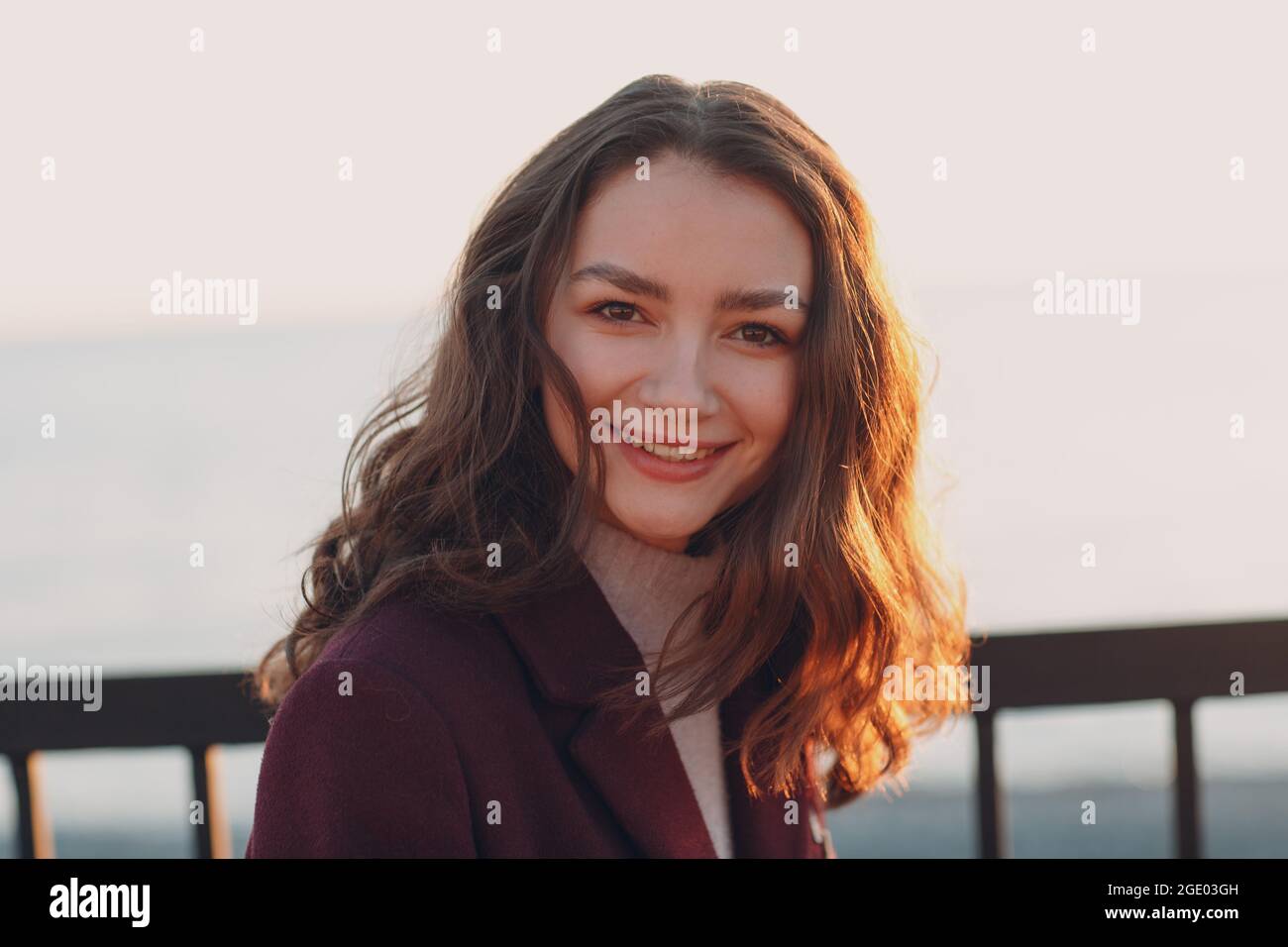 Young smiling brunette woman in coat outdoors portrait Stock Photo - Alamy