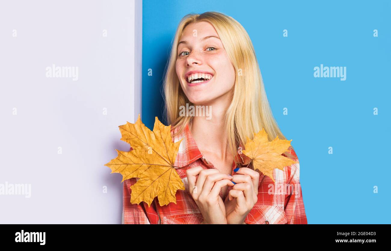 Smiling girl with maple leaves. Autumn fashion trend. Happy woman with Golden leaf. Autumnal mood. Stock Photo