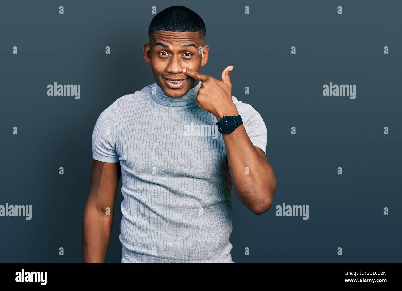 Young black man wearing casual t shirt pointing with hand finger to ...