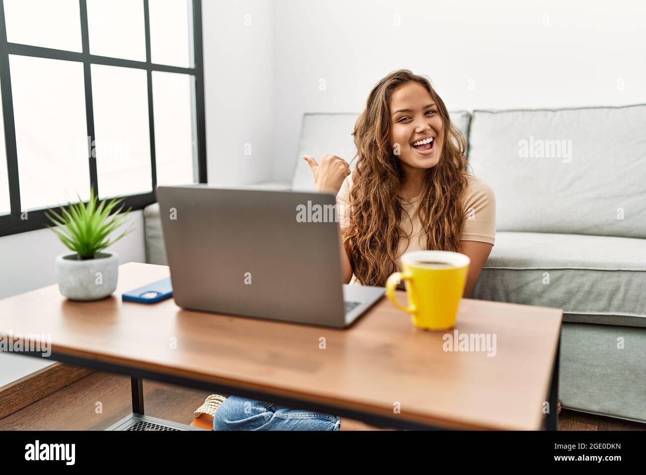 Beautiful hispanic woman using computer laptop at home smiling with ...