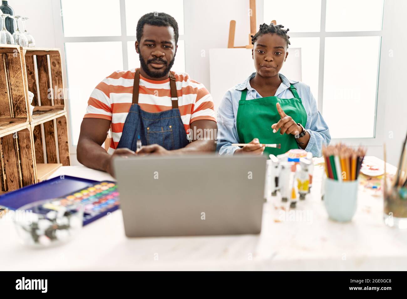 African american painter couple having online paint class sitting on