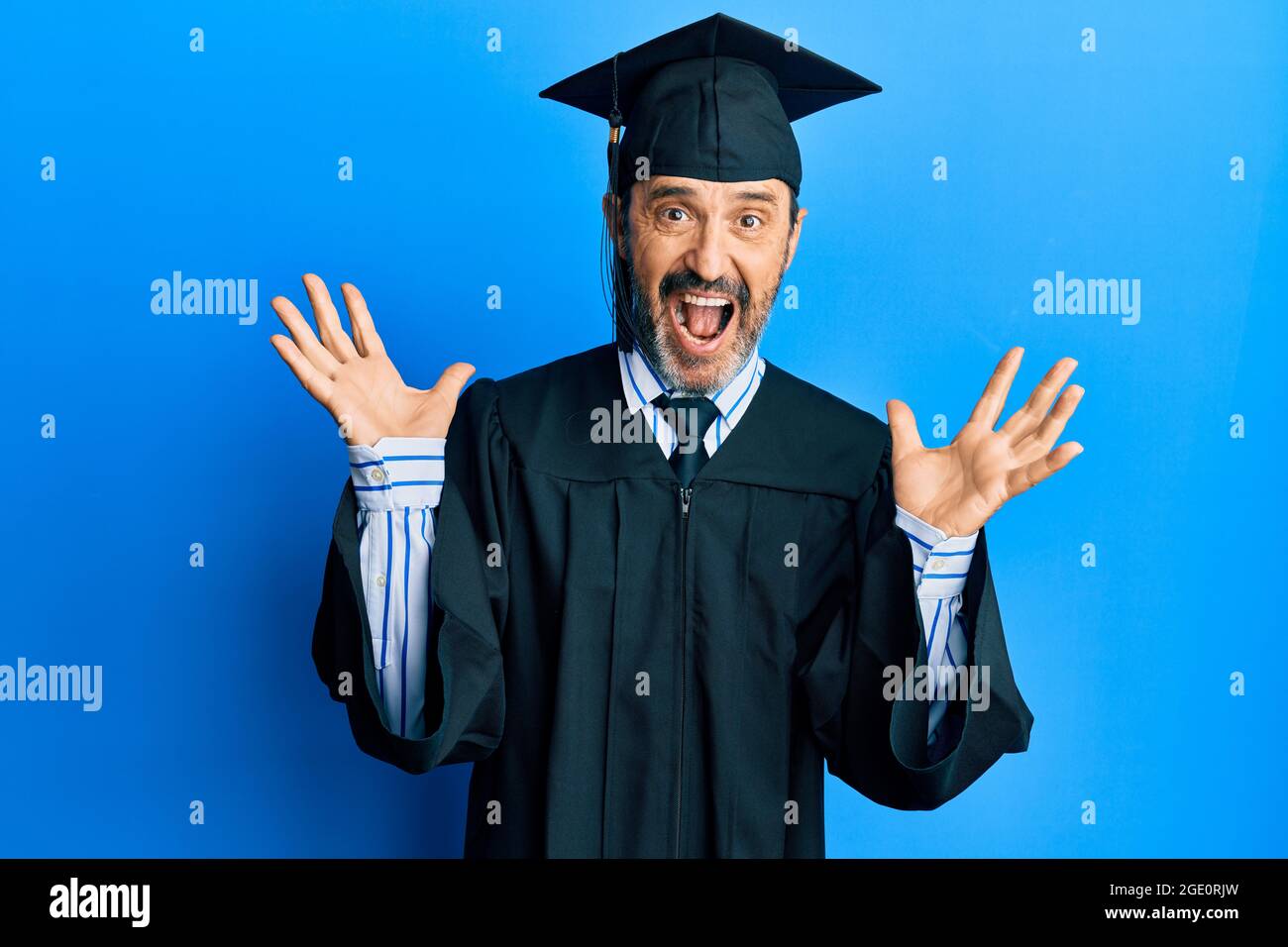 Middle age hispanic man wearing graduation cap and ceremony robe ...