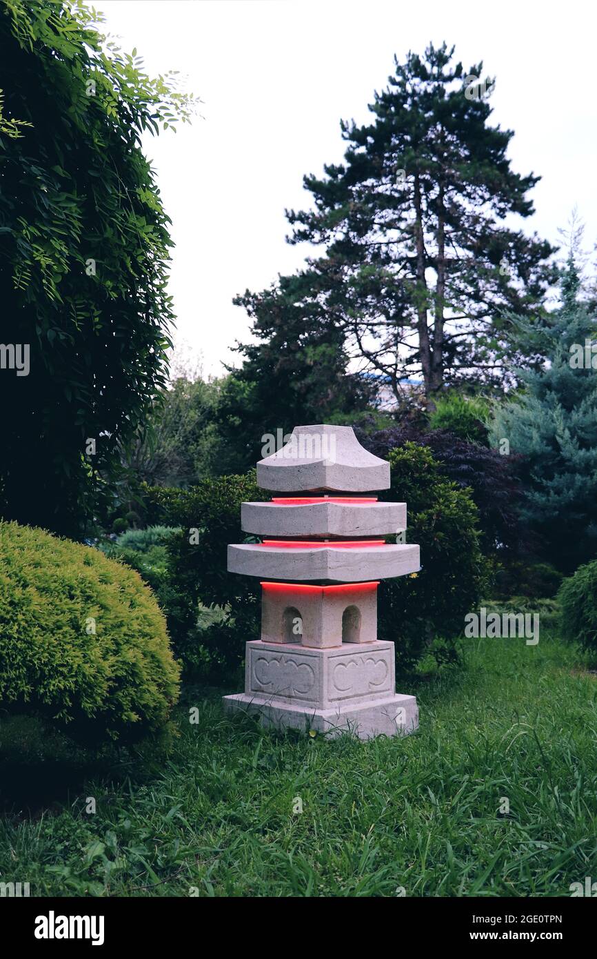 Stone red lantern in japanese garden. Evening in summer japanese garden. Stock Photo