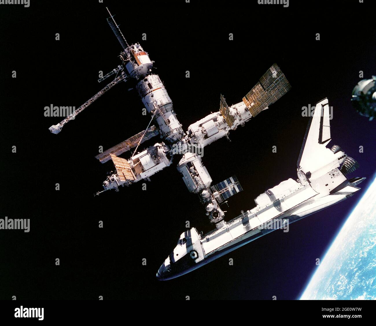 This view of the Space Shuttle Atlantis still connected to Russia's Mir Space Station was photographed by the Mir-19 crew on July 4, 1995. Cosmonauts Anatoliy Y. Solovyev and Nikolai M. Budarin, Mir-19 Commander and Flight Engineer, respectively, temporarily undocked the Soyuz spacecraft from the cluster of Mir elements to perform a brief fly-around. They took pictures while the STS-71 crew, with Mir-18's three crew members aboard, undocked Atlantis for the completion of this leg of the joint activities. Solovyev and Budarin had been taxied to the Mir Space Station by the STS-71. Stock Photo