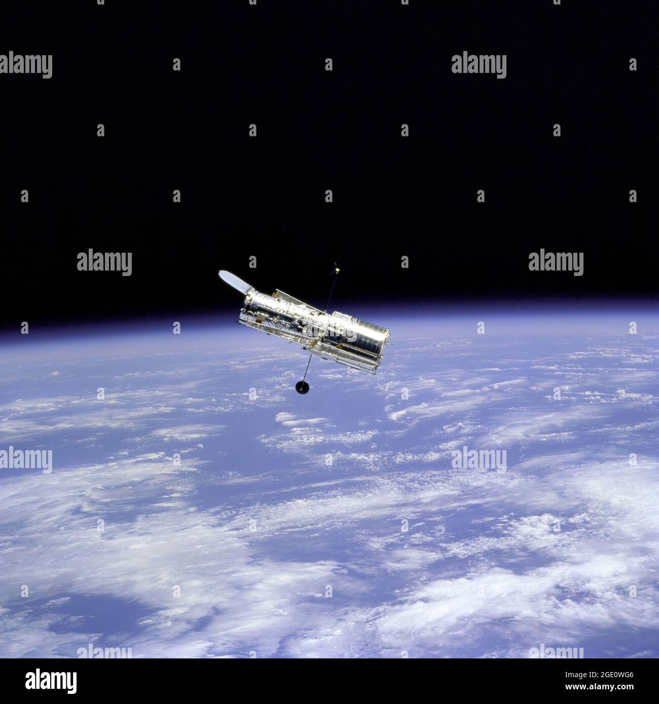 Flyaround of the Hubble Space Telescope (HST) after deployment on this second servicing mission (HST SM-02). Note the telescope's open aperature door. Stock Photo