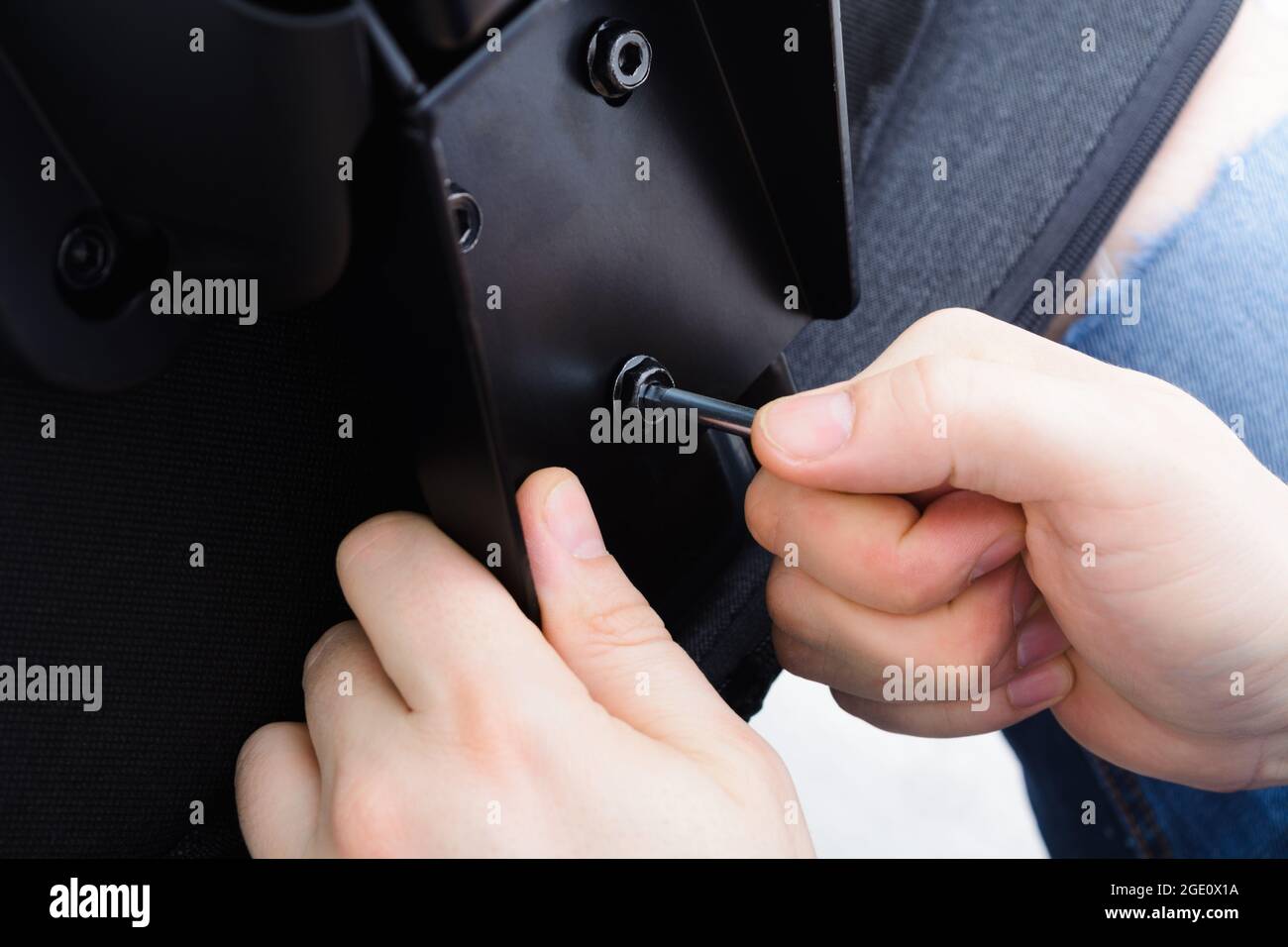 Caucasian man hands screw chair back. Assembling office chair indoors. Step 12 Stock Photo