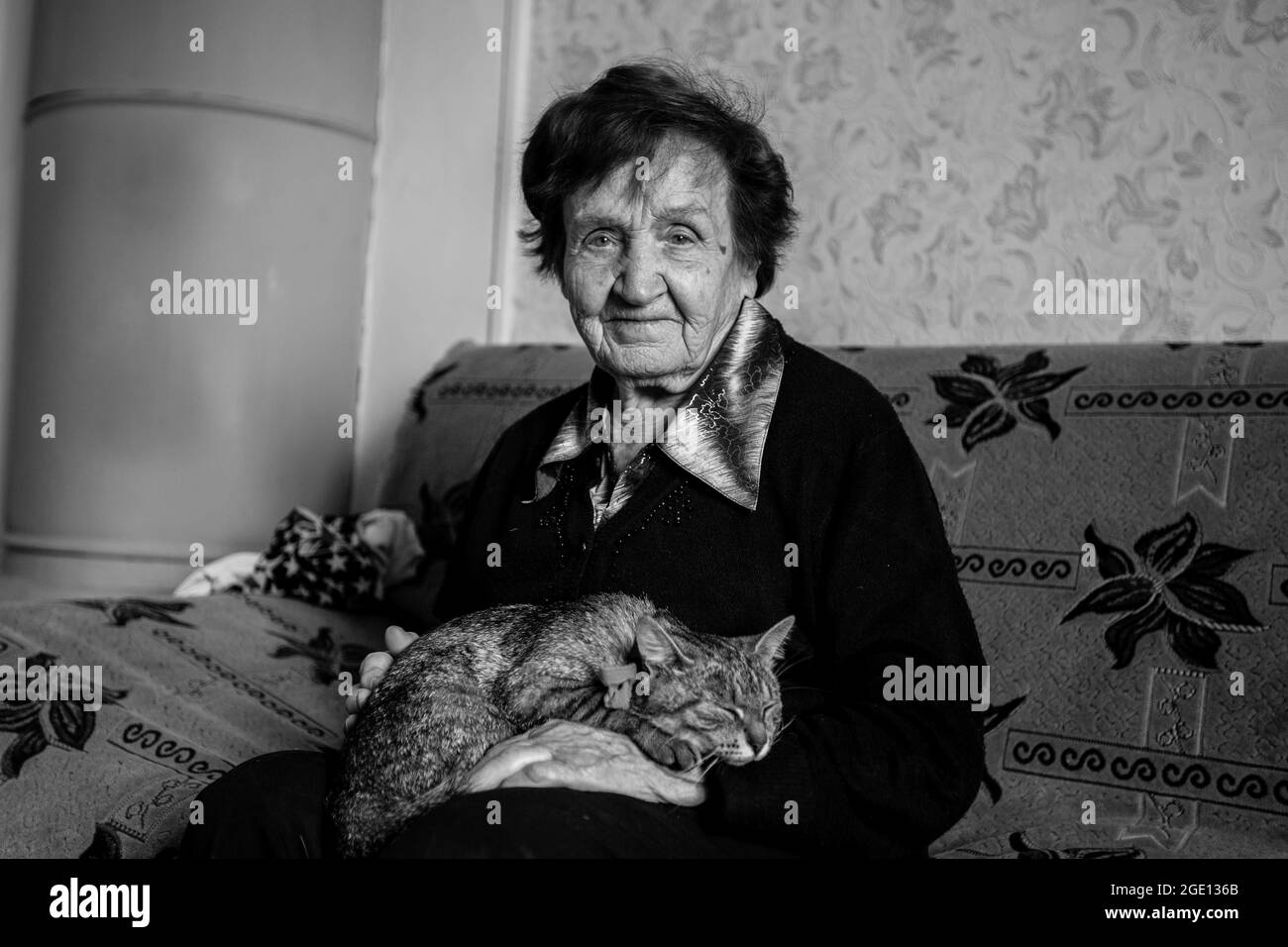 An elderly woman with cat at her home. Black and white photo. Stock Photo