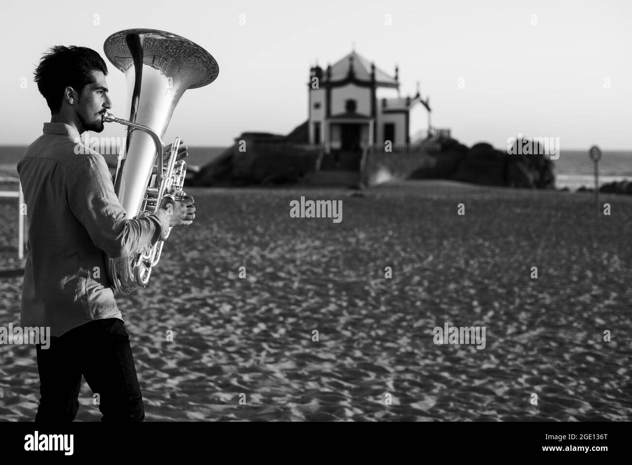 A musician with a tuba on the Miramar Beach, Portugal. Black and white photo. Stock Photo