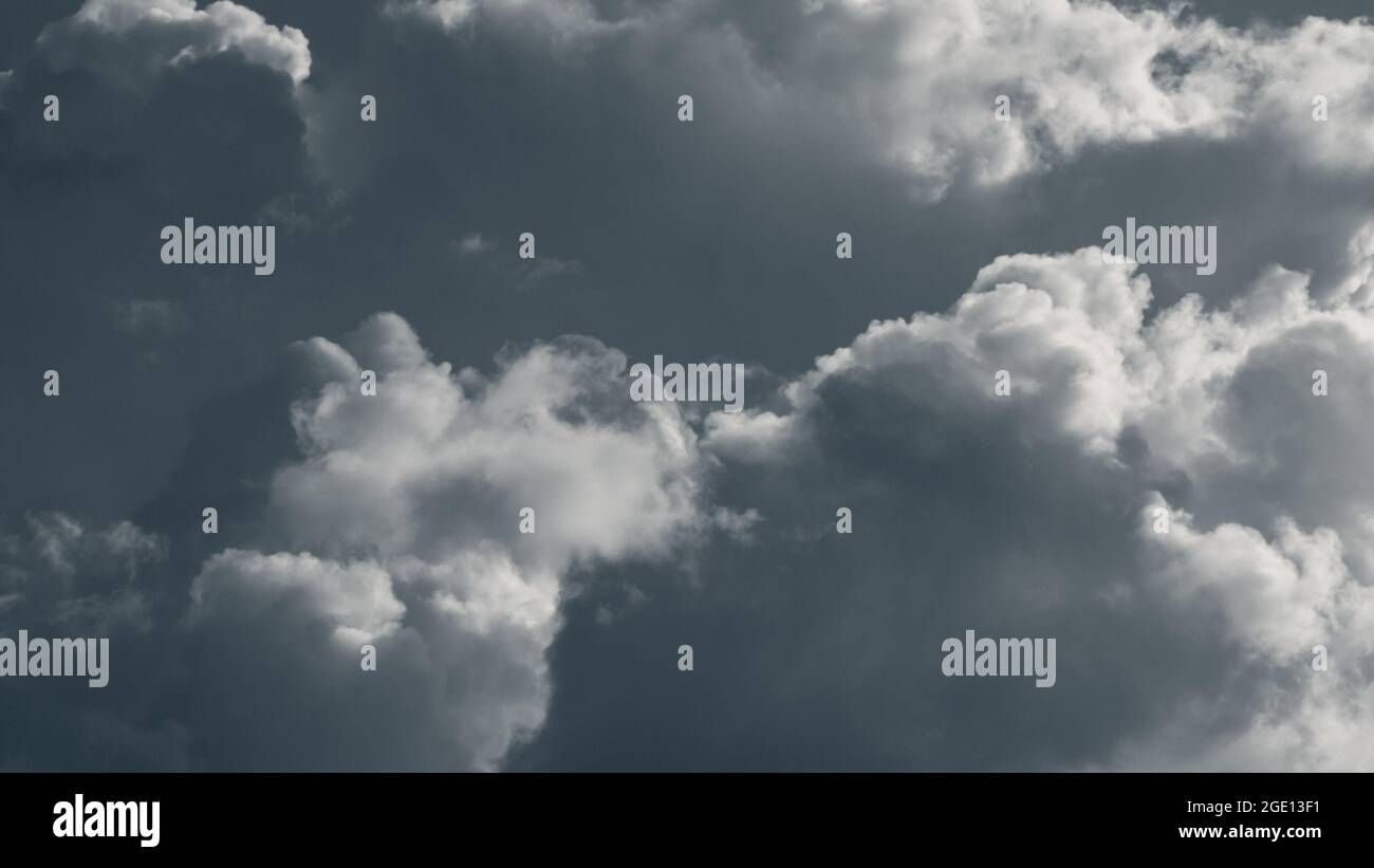 Dramatic rainclouds lit with bright sun, clouds in gray sky Stock Photo