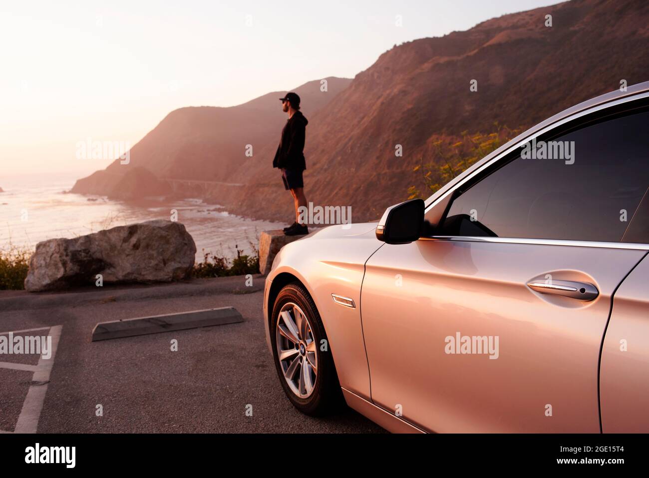 Man watching the sea during sunset at a coastal viewpoint along Highway 1. Big Sur, California, USA. Sep 2019 Stock Photo