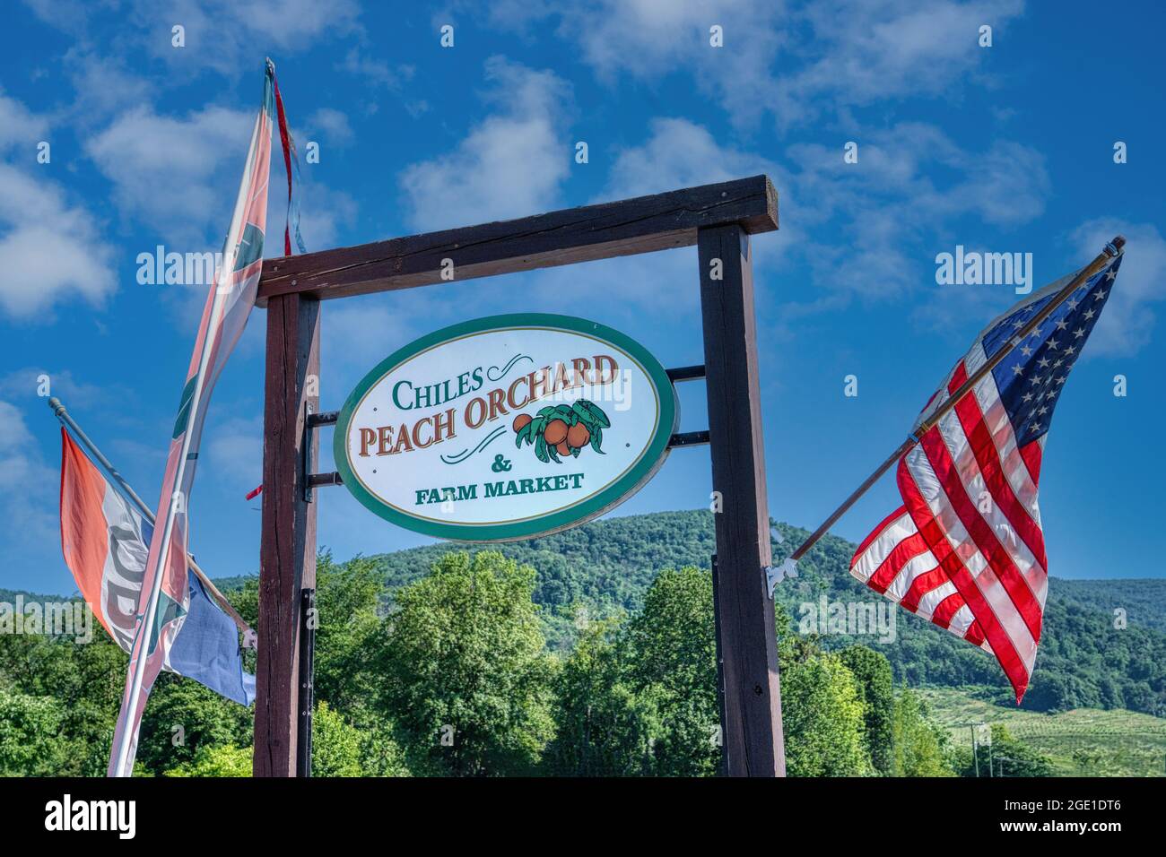 American Flag flies by the sign for Chiles Peach Orchard and Farm
