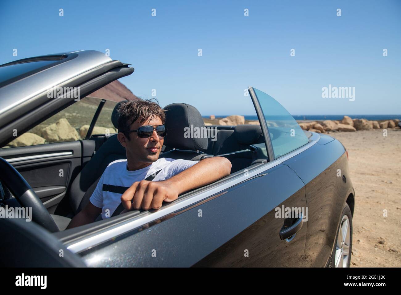 Indian rich man sitting in his convertible car wears sunglasses and looks  to the side. Realized man sitting in an expensive car. Forty year old person  Stock Photo - Alamy