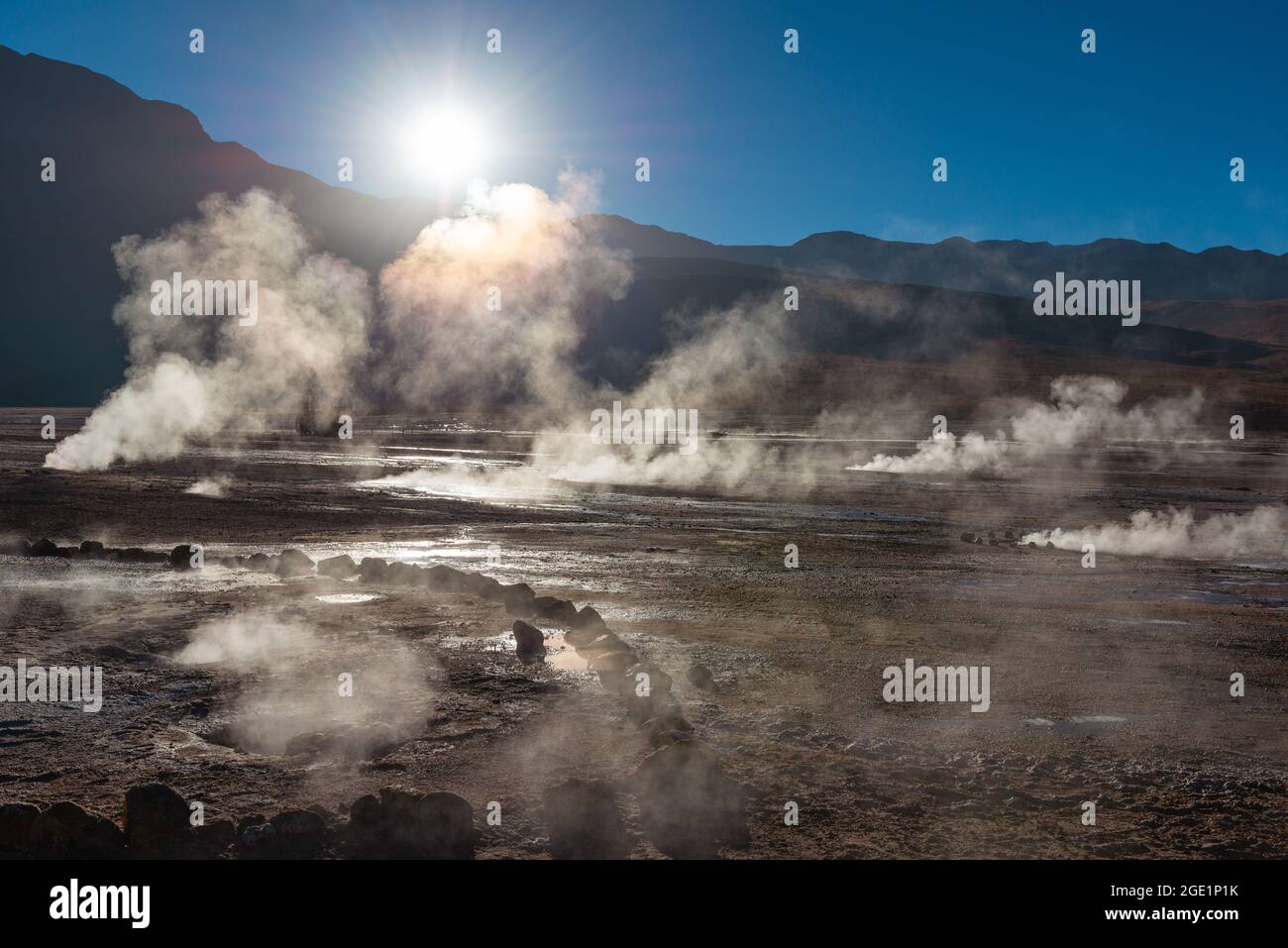 El Tatio geyser field landscape at sunrise with hot steam and sunbeam, Atacama Desert, Chile. Stock Photo