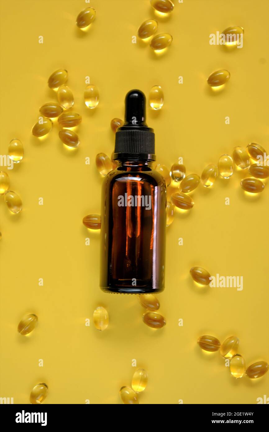 Vitamin D. Oil extract and gelatin capsules with vitamin D on a bright