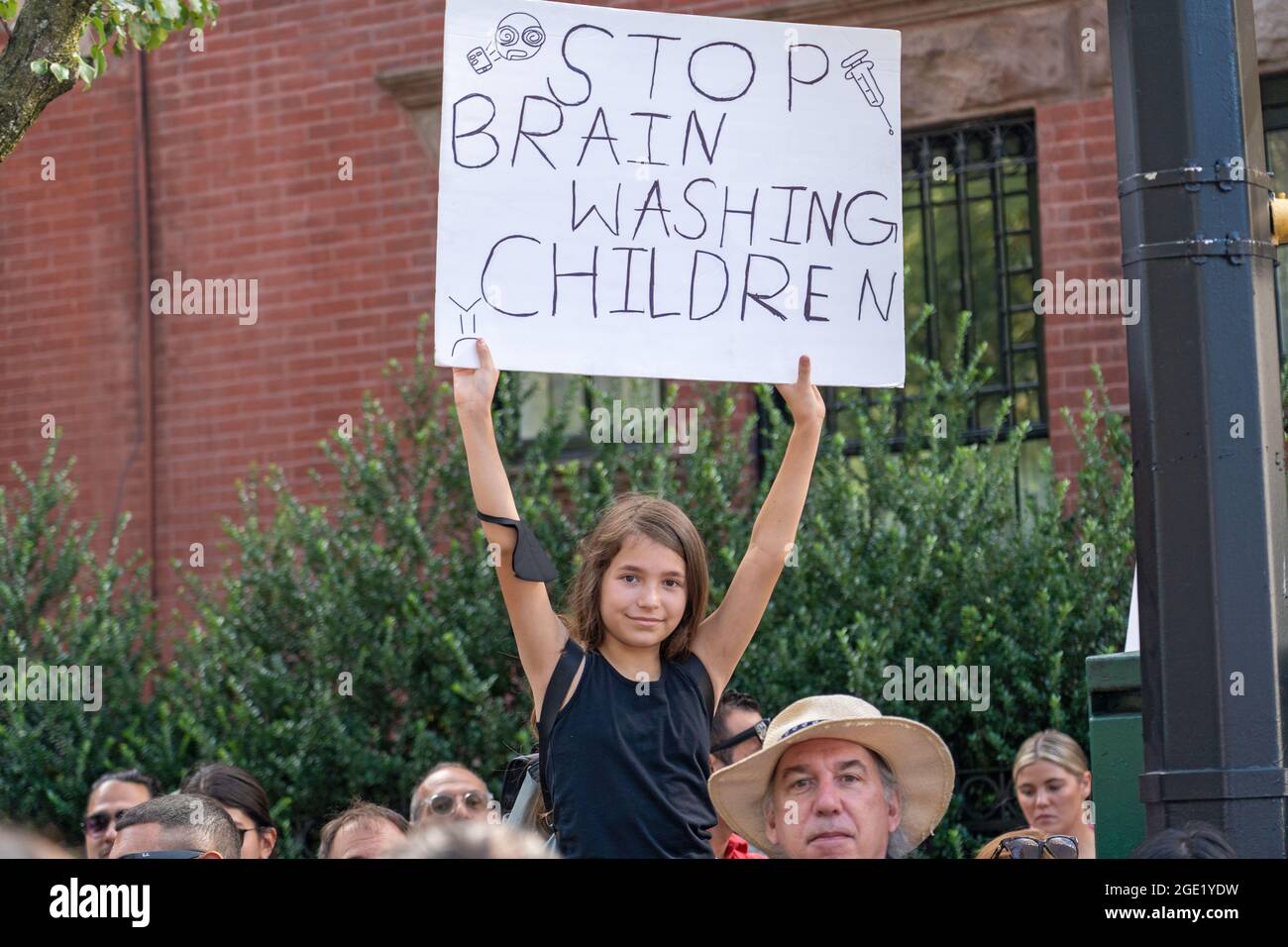 New York, United States. 15th Aug, 2021. A girl holds a sign that says stop brain washing children during a Republicans Rally against COVID vaccine mandates outside Gracie Mansion in New York City.NYC vaccine mandate starts Monday, August 16th; Proof of coronavirus (COVID-19) vaccination will be required to attend indoor restaurants, gyms, and entertainment venues with enforcement of the mandate to begin on September 13th. Credit: SOPA Images Limited/Alamy Live News Stock Photo