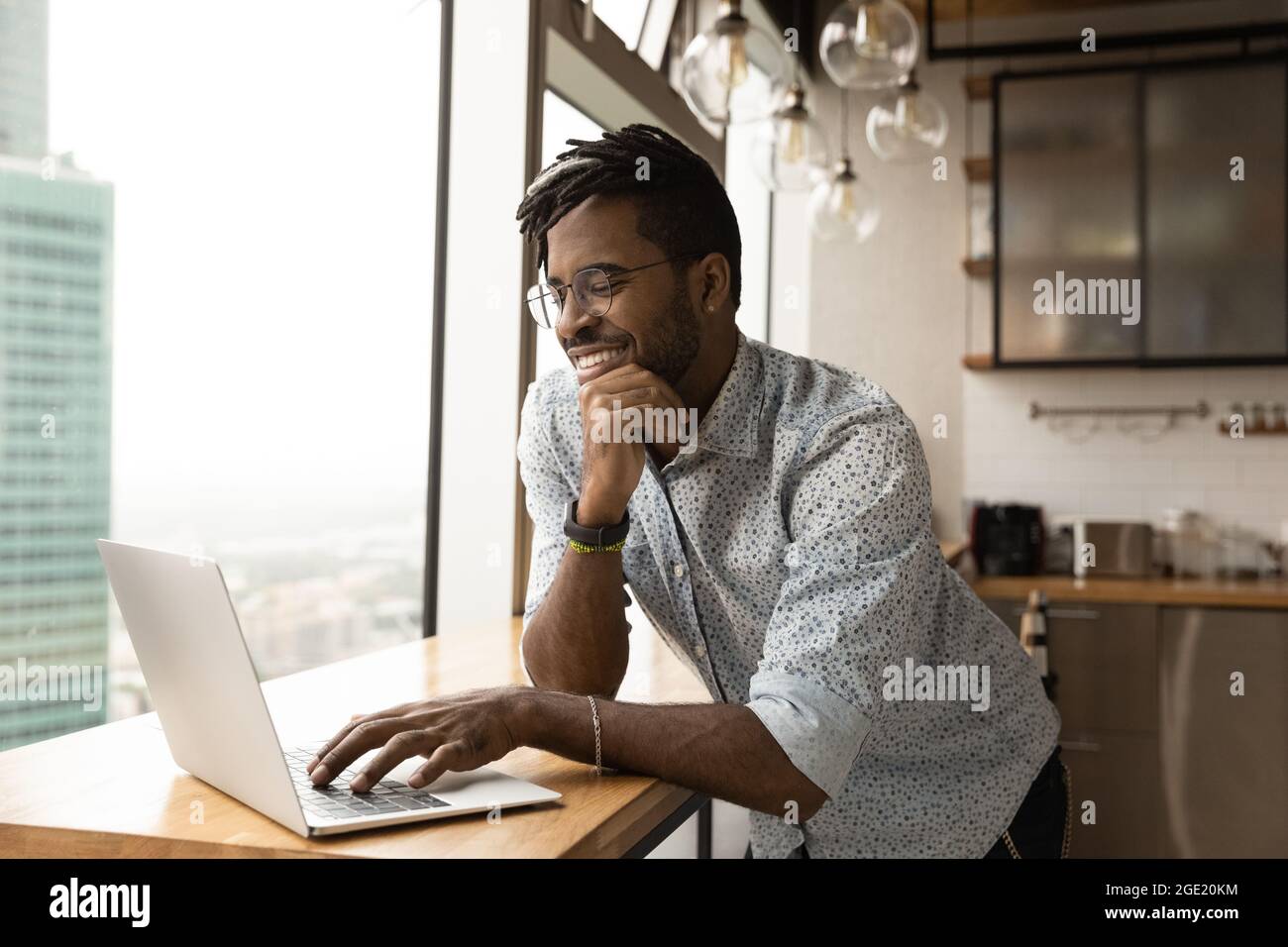 African guy working on computer smiling lead pleasant remote chat Stock Photo