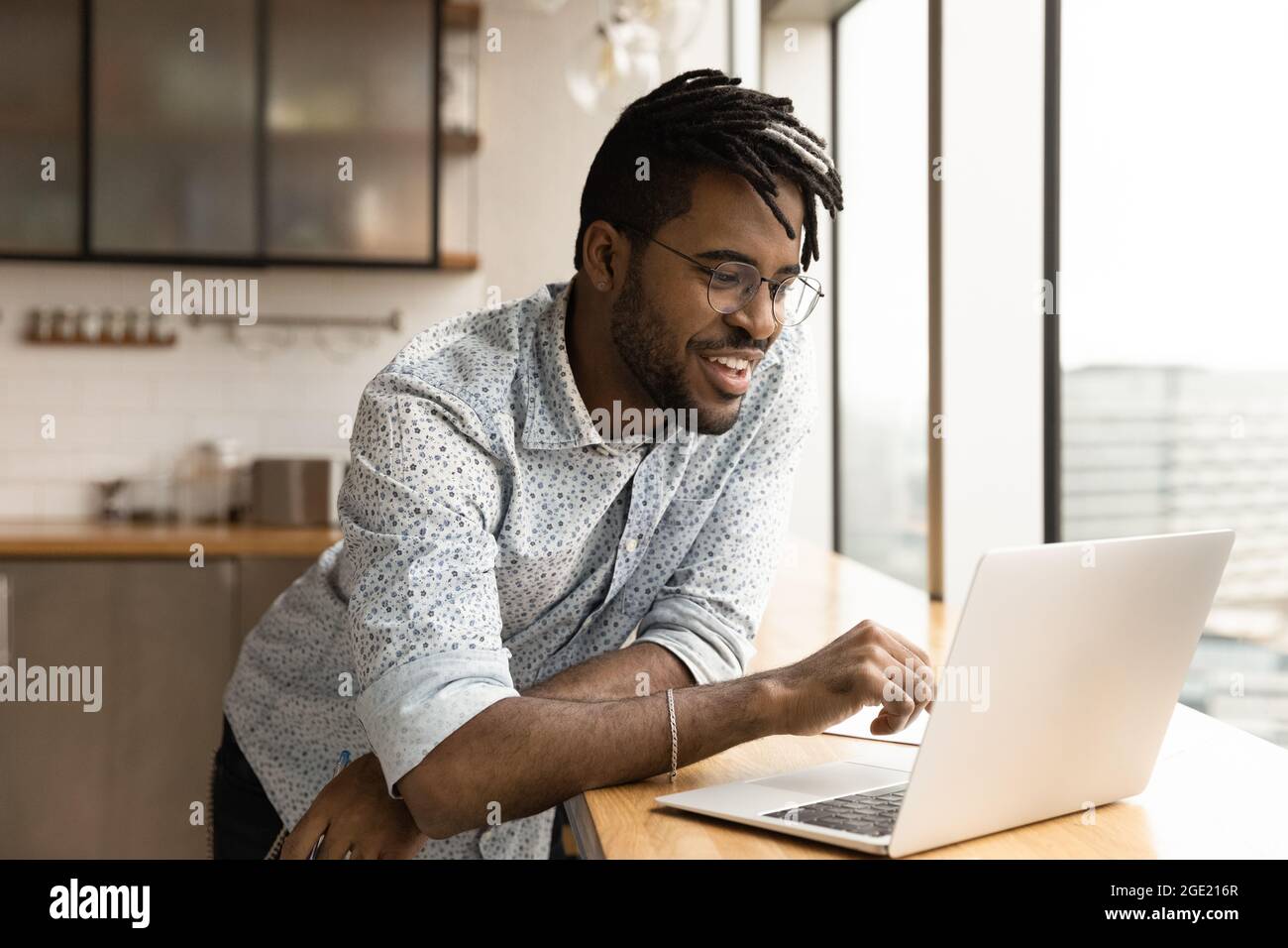 Handsome hipster guy using laptop watch webinar entertaining online content Stock Photo