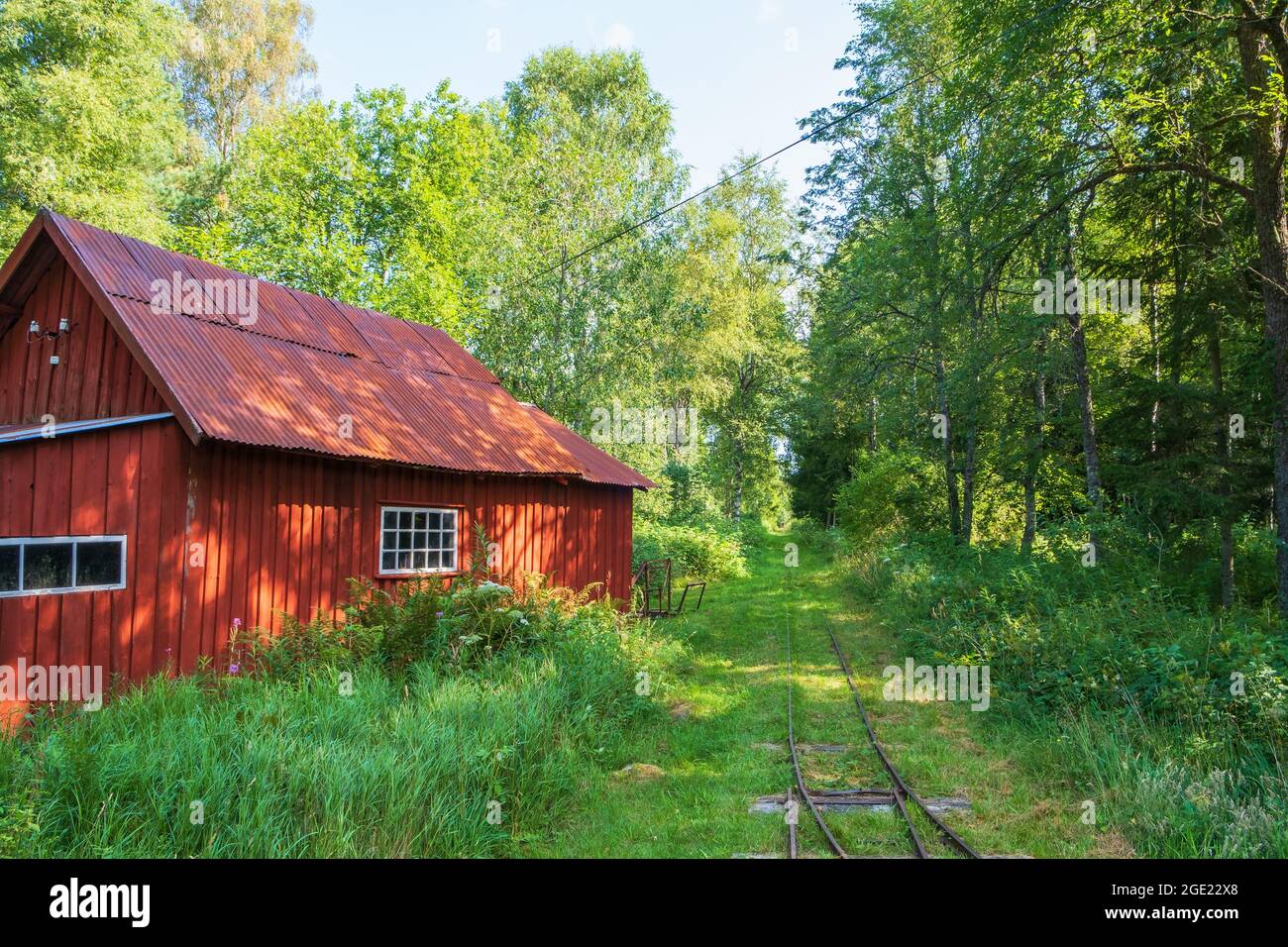 Old red shed at a narrow-gauge railroad in the woodland Stock Photo