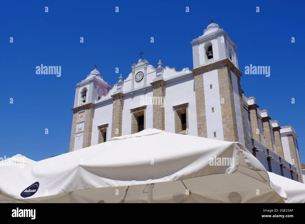 Church of Santo Antao and cafe awnings in Giraldo Square at Evora in Alentejo, Portugal Stock Photo