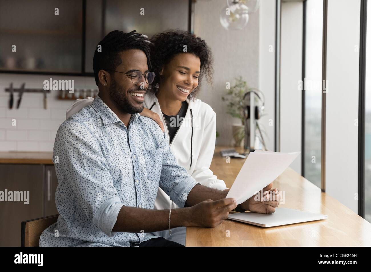 African couple holding papers reading document glad about good news Stock Photo