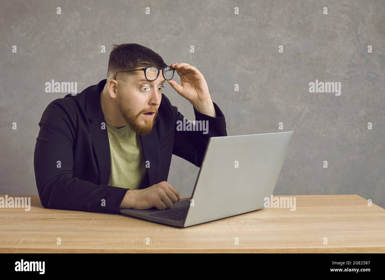Young man is shocked while teleworking. Stock Photo