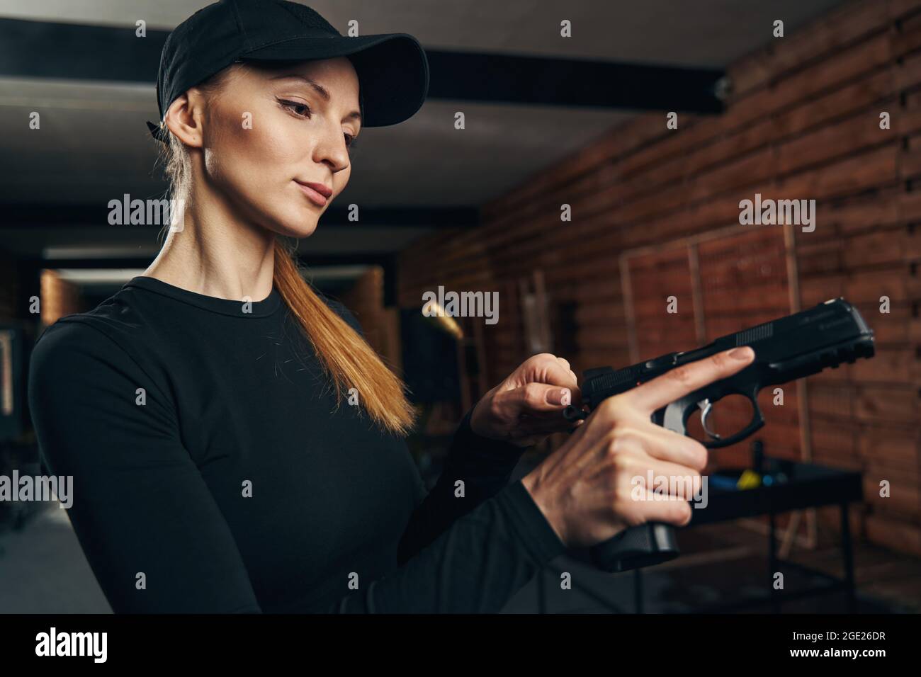 Serene experienced female shooter cocking her gun Stock Photo Alamy