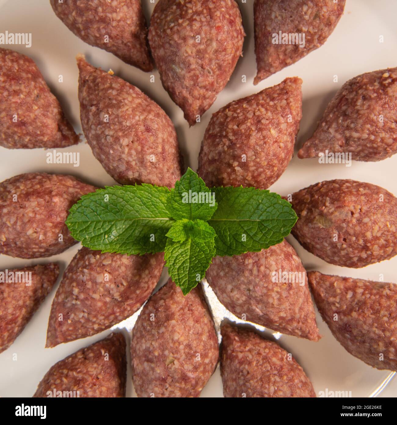 Traditional kebbe and pita bread on big round plate in lebanese restaurant Stock Photo