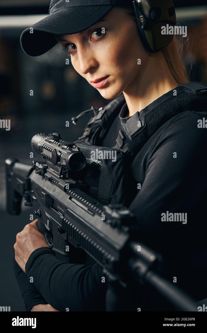 Female shooter in a cap looking ahead Stock Photo