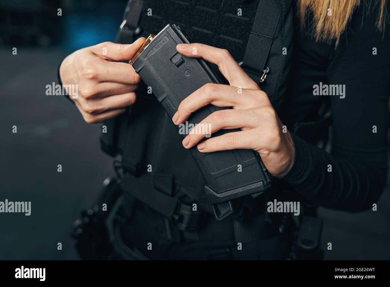 Skilled Caucasian female shooter loading her weapon Stock Photo
