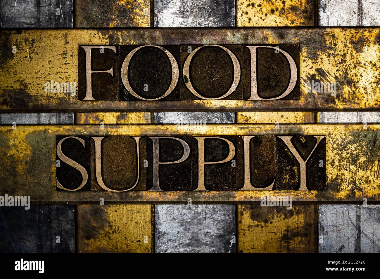Food Supply text message on vintage textured grunge copper and gold background Stock Photo