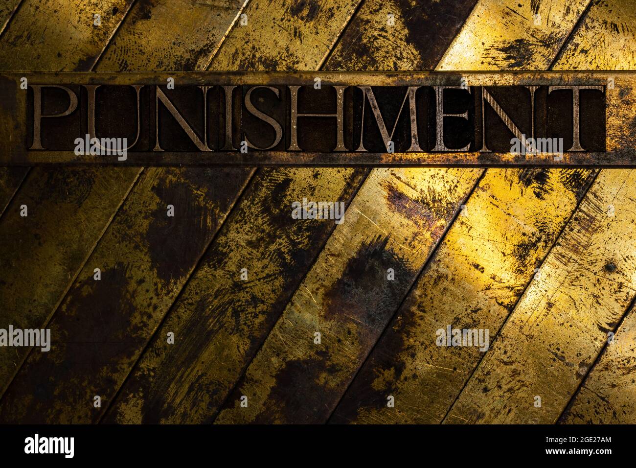 Punishment text formed with real authentic typeset letters on vintage textured silver grunge copper and gold background Stock Photo