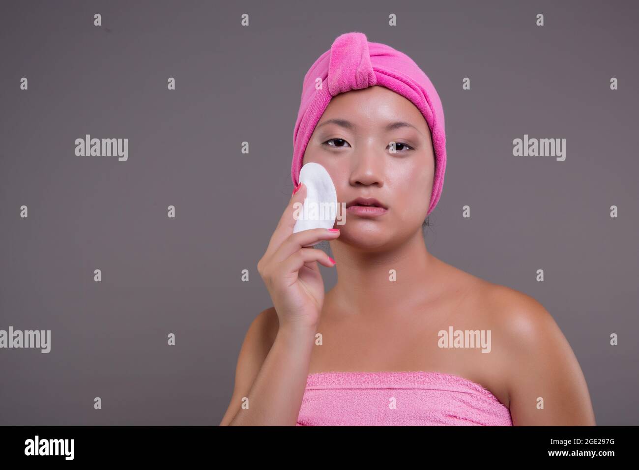 Young Chinese girl taking care of her skin after showering, beauty concept Stock Photo