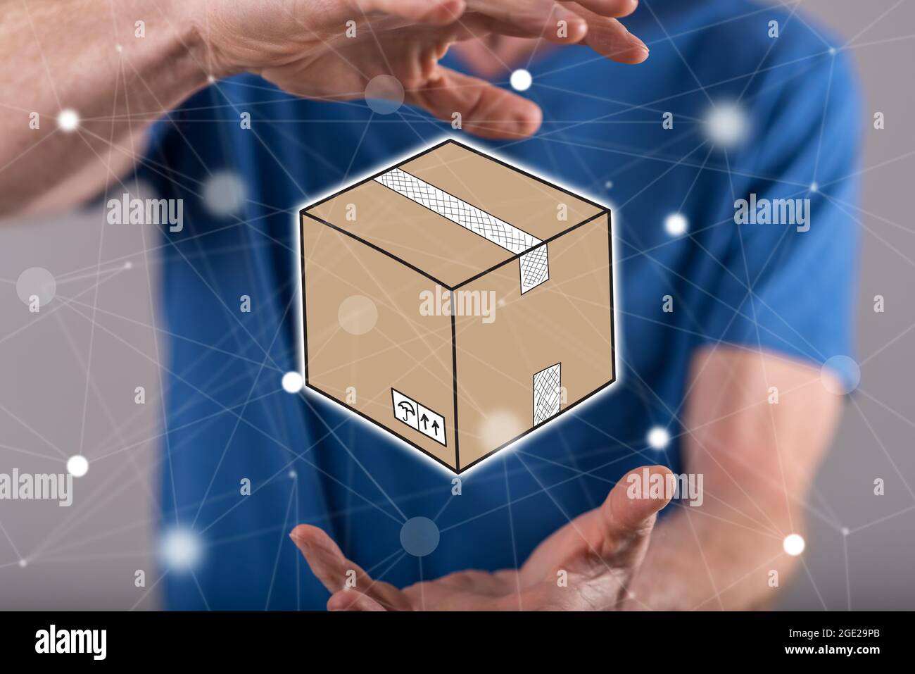 Packaging concept between hands of a man in background Stock Photo - Alamy