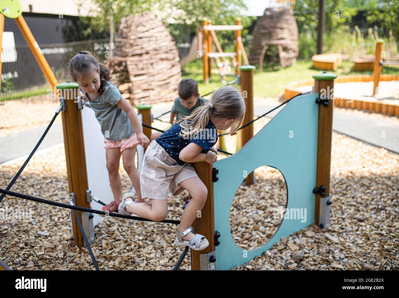 Group of small nursery school children playing outdoors on playground. Stock Photo