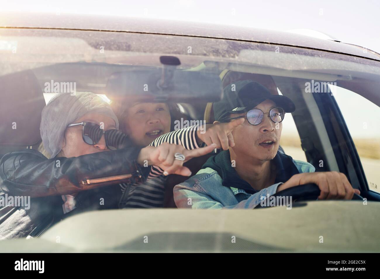 group of happy asian friends enjoying a sightseeing trip by car Stock Photo