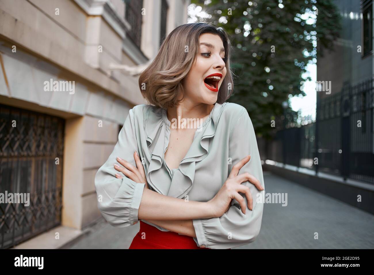 pretty woman with red lips walking down the street rest Stock Photo - Alamy