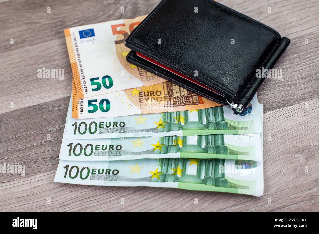 50 and 100 euro banknotes with wallet on wooden top Stock Photo - Alamy