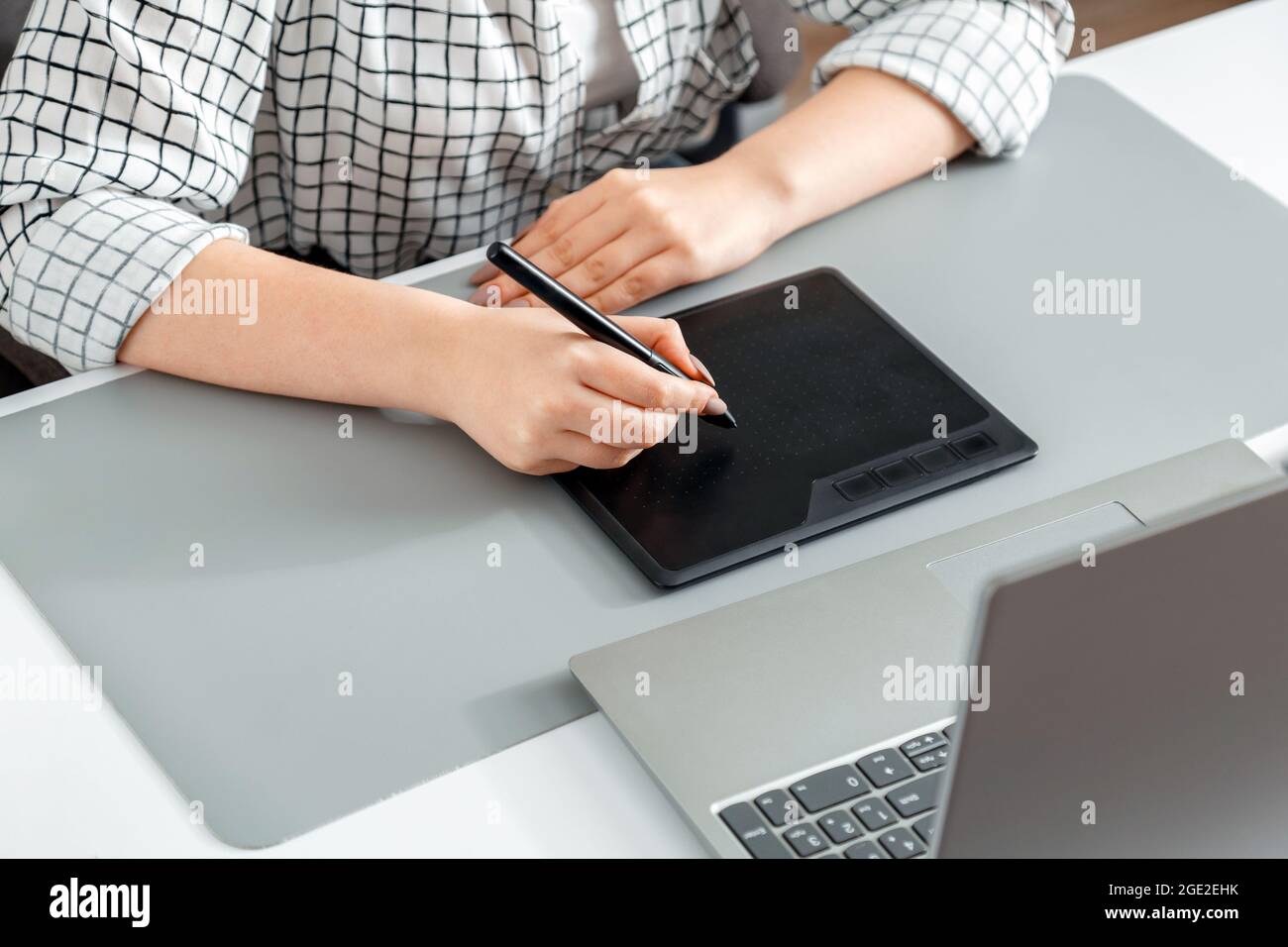 Creative designer working with professional equipment. Close up female hands designer editor artist drawing digital tablet laptop at home office Stock Photo