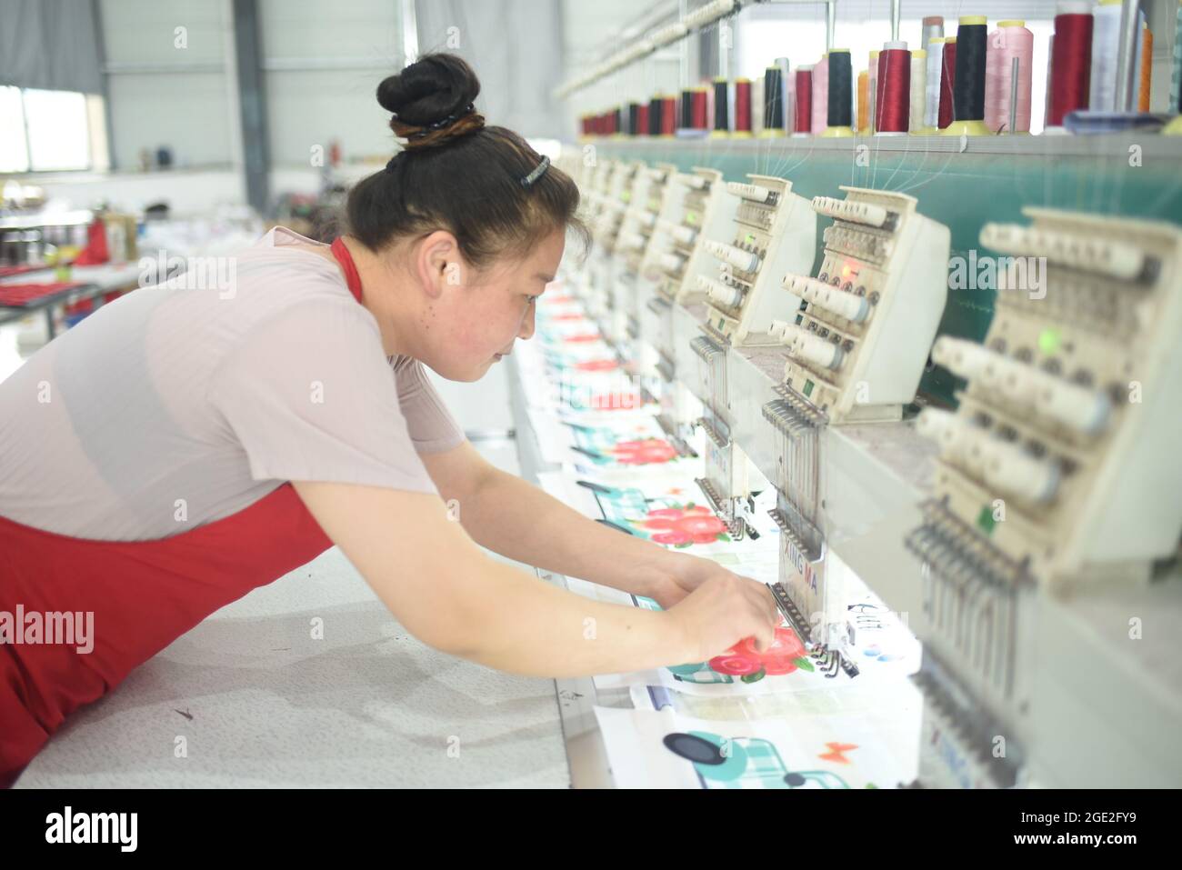 August 16, 2021, Lianyungang, Lianyungang, China: On August 16, 2021, the ''Embroidery Girl'' in the Economic Development West District of Donghai County, Lianyungang City, Jiangsu Province, is producing and exporting embroidery products in the workshop. In the past year, Donghai County, Lianyungang City, Jiangsu Province, has innovated service measures such as ''paying for'five social insurances and one fund', free vocational skills training, and housing resettlement'' by increasing the number of original registered cardholders to consolidate poverty alleviation. The original registered cardh Stock Photo