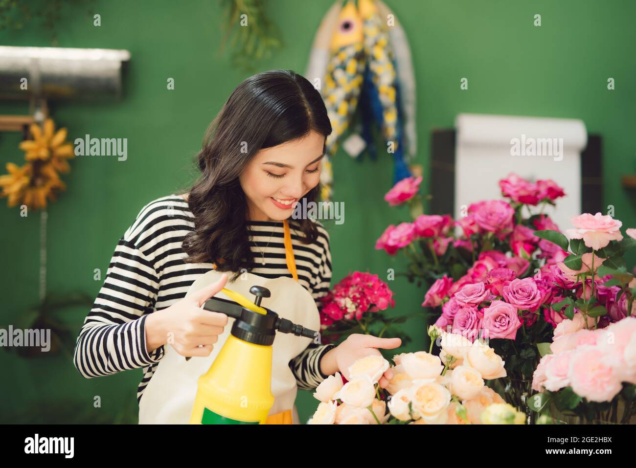 Vietnamese young flower shop owner spraying bouquets Stock Photo Alamy