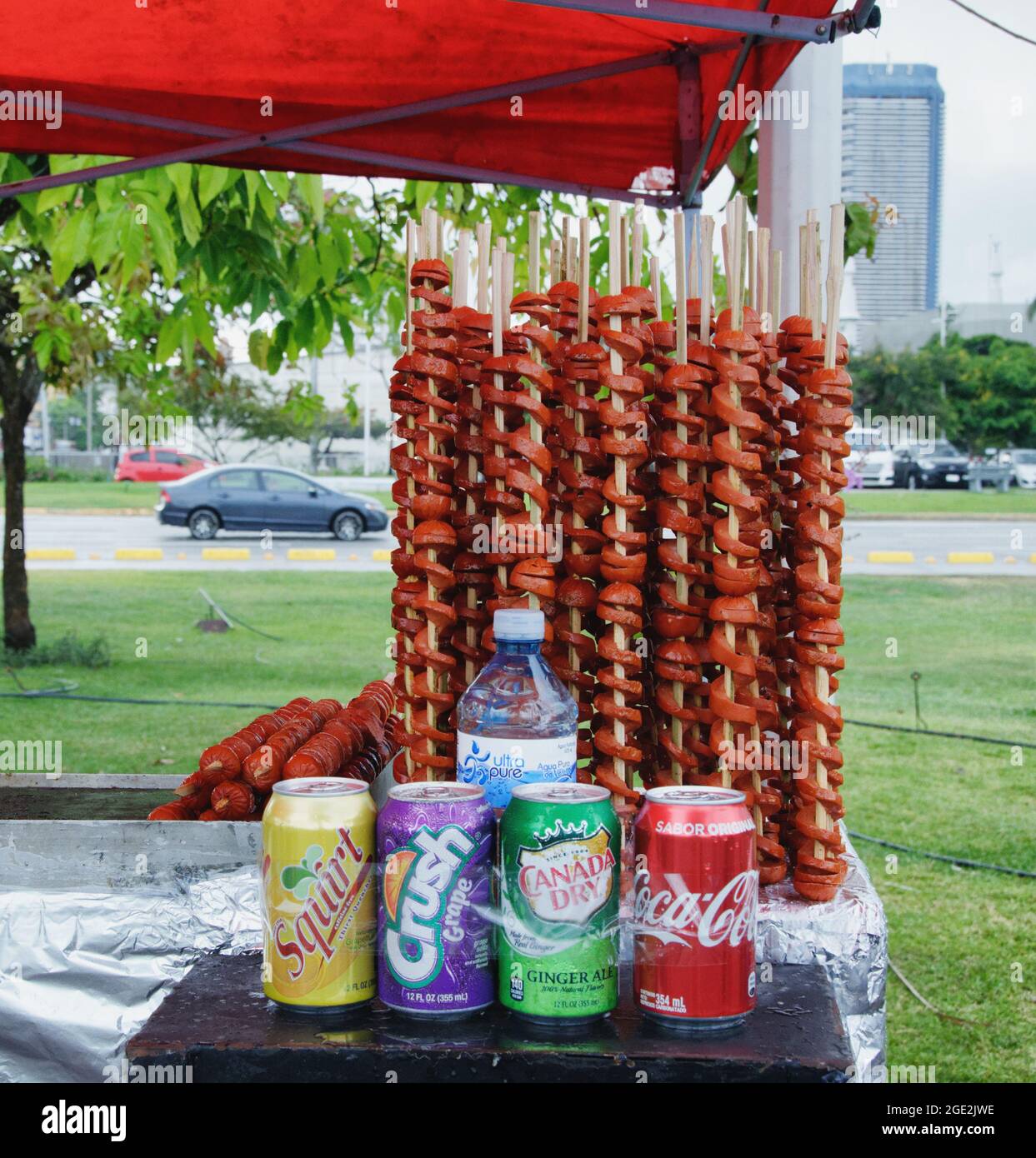 Cans on drinks and doughnuts on spikes as part of a hawker stall selling food and drink, Panama City, Panama, Central America Stock Photo