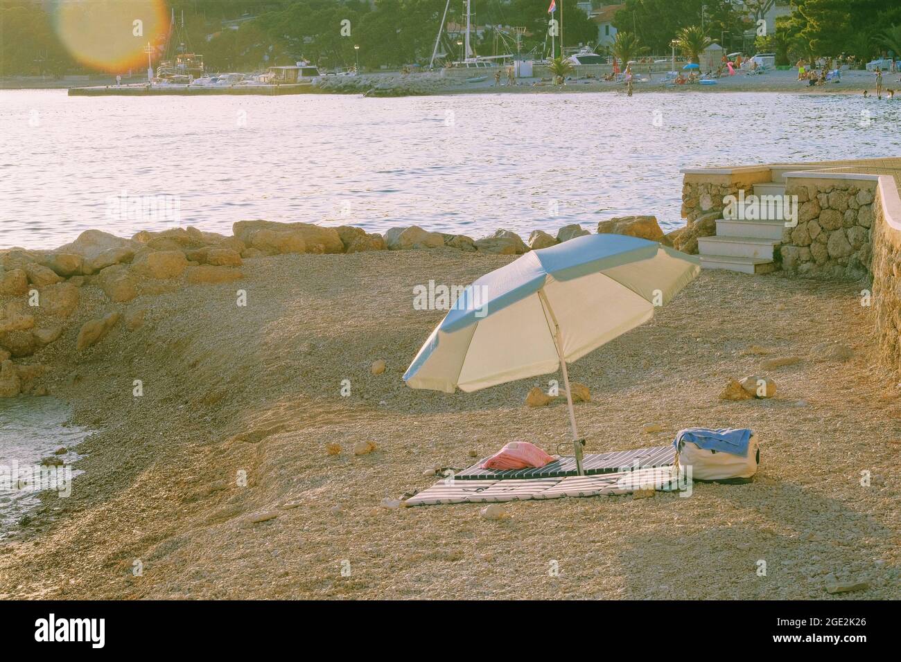 Beach umbrella for relax and comfort on sea coast. Happy summer vacations and resort concept. Sunny day. Stock Photo