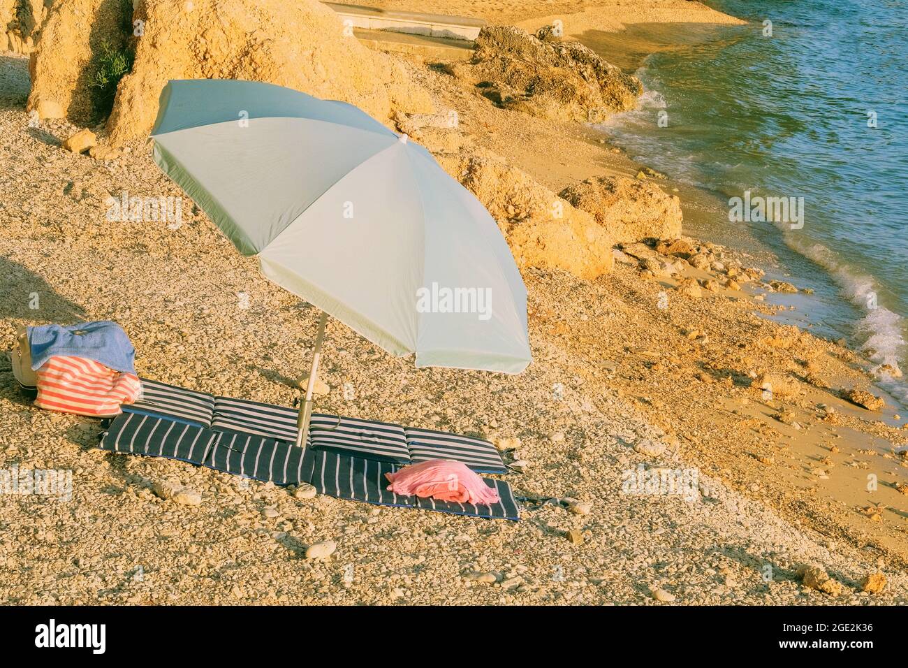 Beach umbrella for relax and comfort on sea coast. Happy summer vacations and resort concept. Seascape in sunny day. Stock Photo