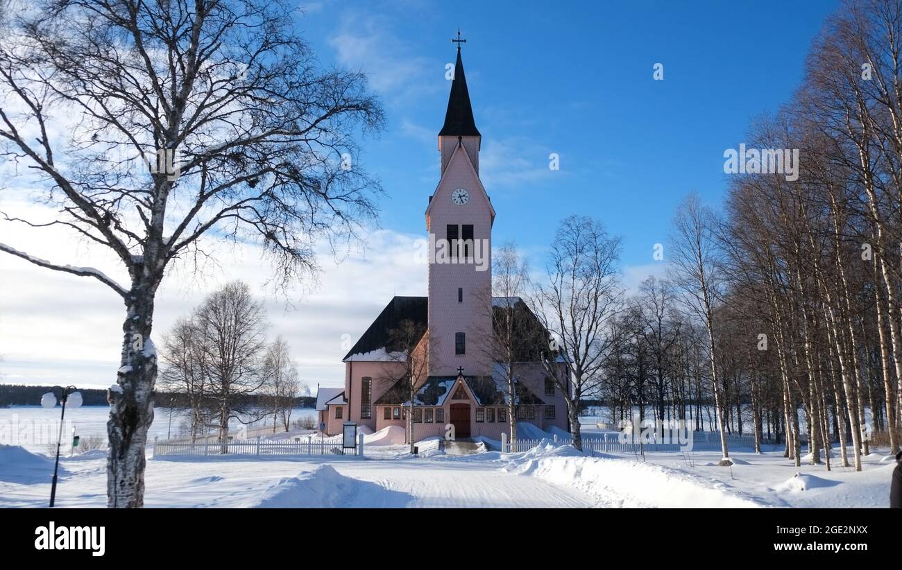 Beautiful church in Sweden during a sunny day with snow in winter season. Perfect Christmas background. Quiet and peaceful landscape. Stock Photo