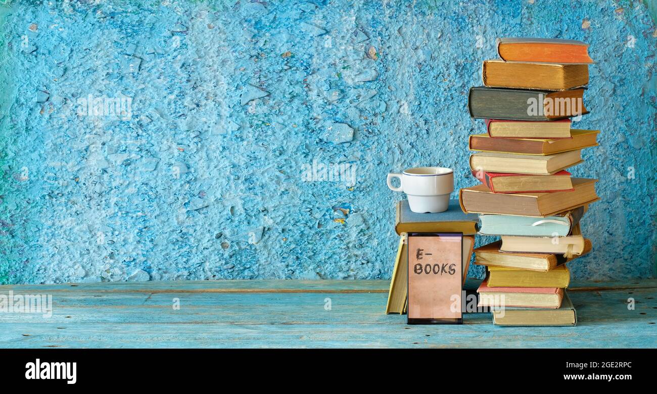 Stack of books and an e-book reader. E- Book, book fair,reading,realaxing,education concept. Free copy space Stock Photo