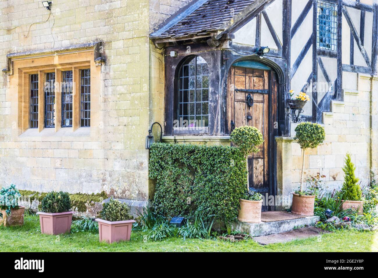 The corner of an unusual, pretty Cotswold house. Stock Photo
