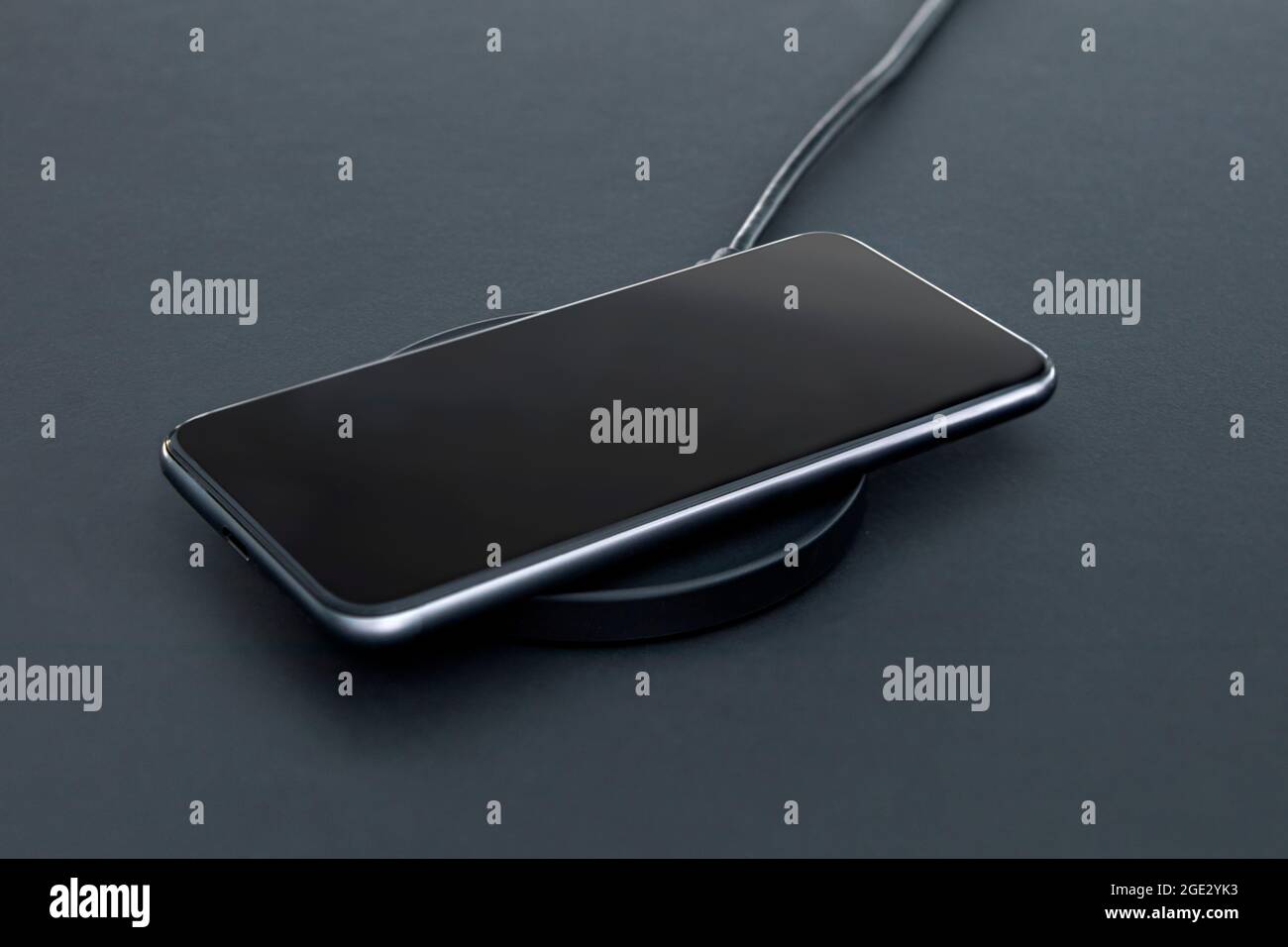 Modern Devic's Close-up of luxury smartphone while recharging battery using wireless ...